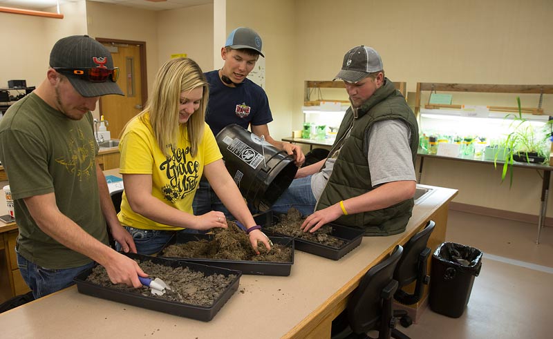 Students in a agriculture lab science class working with dirt.