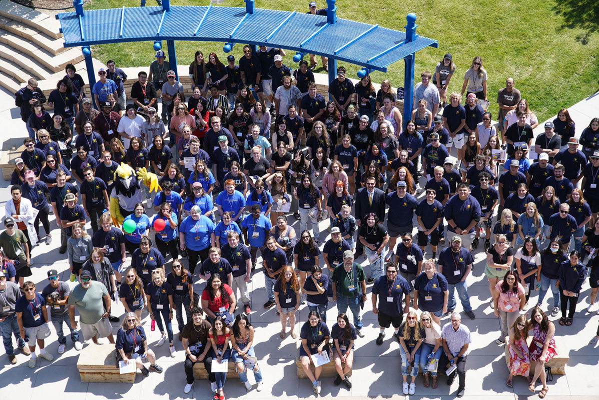 photo of all the students attending the Kick Off event from the roof of a near by building. It's a large group of people looking up at the camera.
