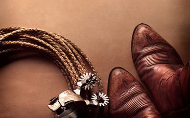 Cowboy boots, spurs and a curled rope