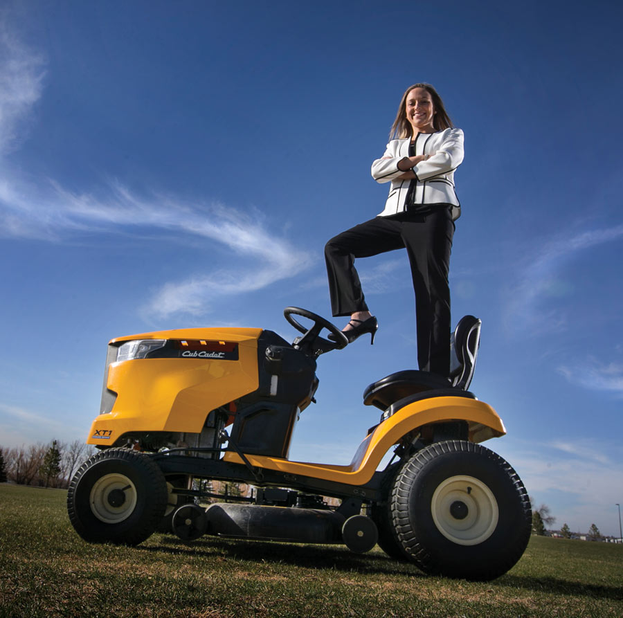 Bailey Nowak standing on lawn mower