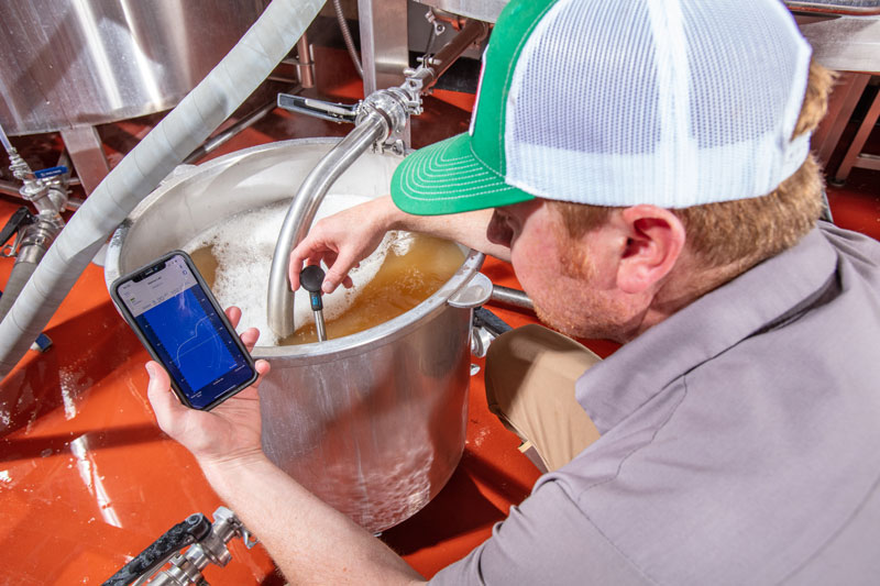 Bond’s Brewing Company owner  Jay Bond takes temperature of the mixture