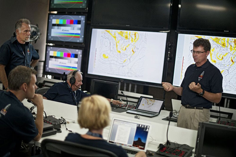 photo of Don Day talking to a group of people in a studio with computers and screens all around them.