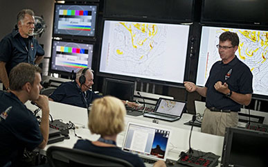 photo of Don Day talking to other people in headsets in a TV station with computers and screens.