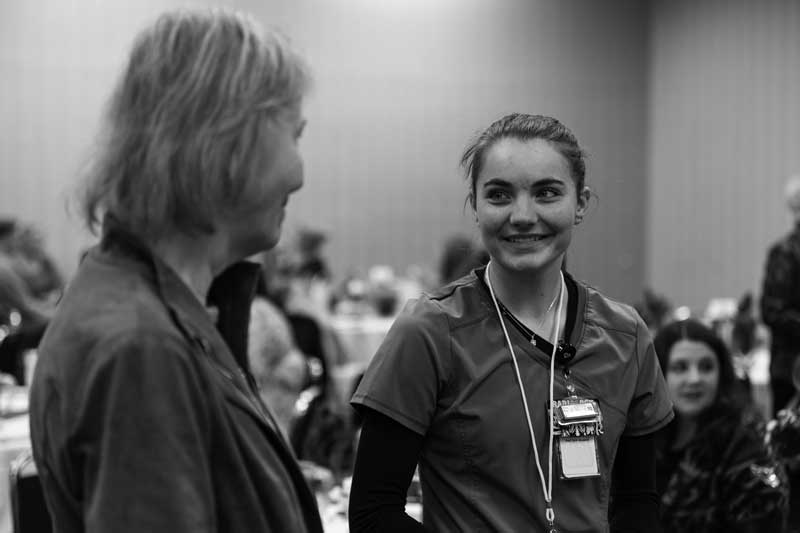 A donor speaking to a student at the scholarship luncheon
