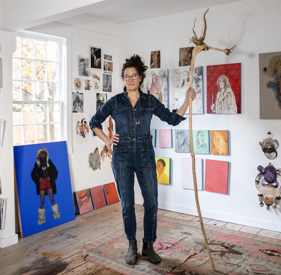 June Glasson standing in studio with artwork behind her