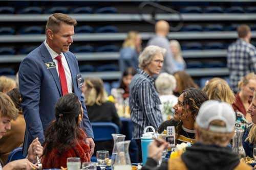 Dr. Schaffer talking to students and donors at a table during the Scholarship Luncheon on campus