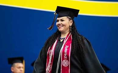 Jennifer Lamblin walking across stage at commencement