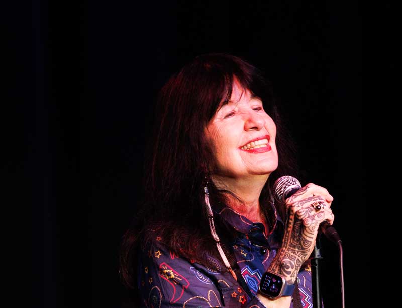 Joy Harjo holding a microphone