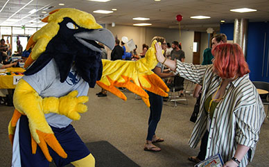 Photo of LCCC mascot Talon high fiving a student.