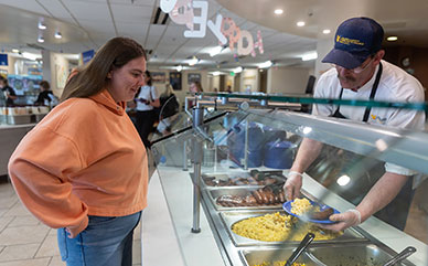 female student being served food in the dining hall