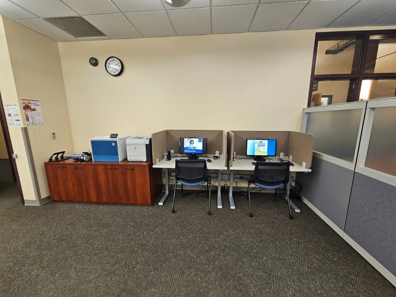 Workstation with staplers, tape, paper cutter, charging staton, pens and pencils, etc.and two adjustable tables and computers