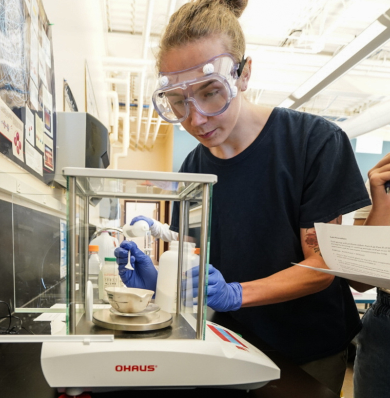 a student measuring chemicals in class lab