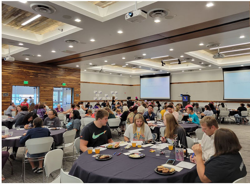 Gear Up event on campus in the ANB Bank Leadership Center with students at round tables talking