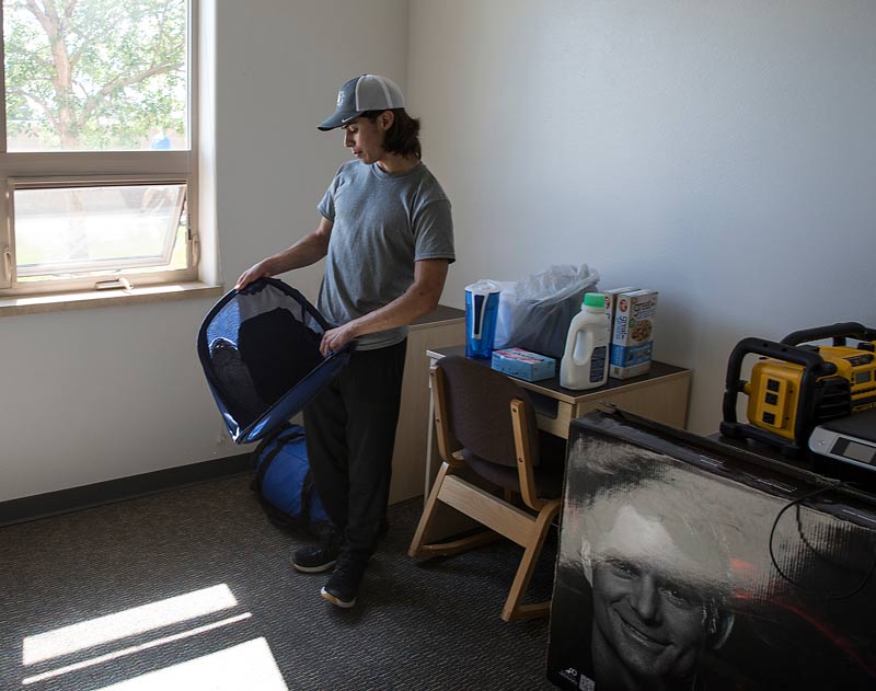 student unpacking in dorm room