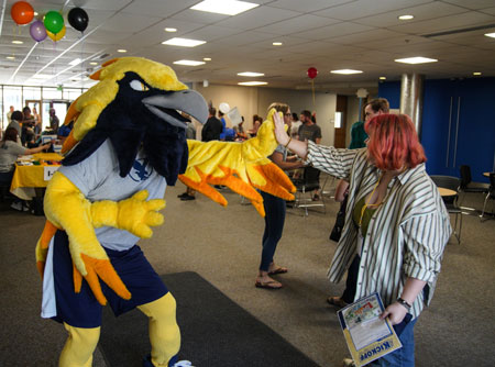 Photo of LCCC mascot Talon high fiving a student.