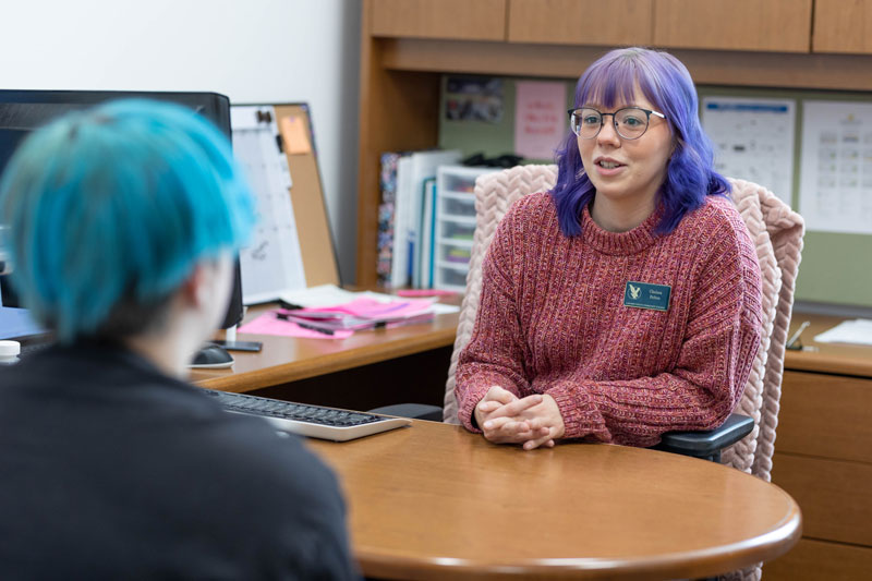 photo of a student talking to a GEAR UP coordinator in an office