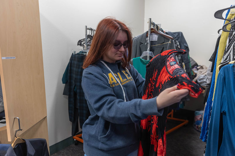 photo of a student holding up a dress in the LCCC Professional Clothing Bank