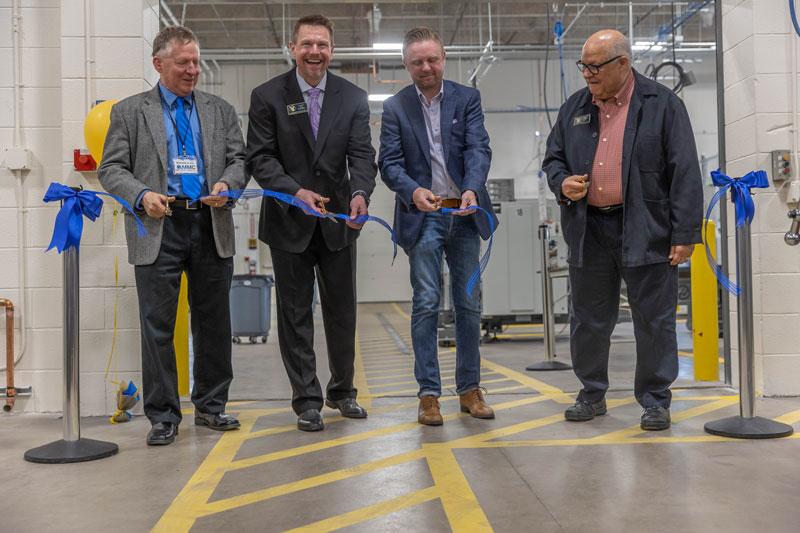 photo of four people cutting a long ribbon in the AMMC 