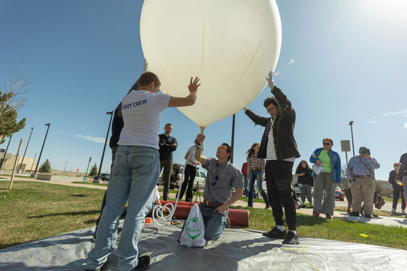 photo of students holding a weather balloon about to be launched