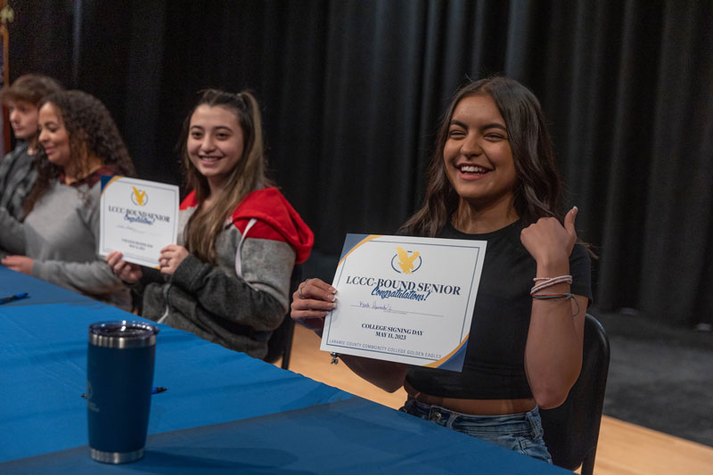 Photo of South High School students holding up their LCCC signing certificate.