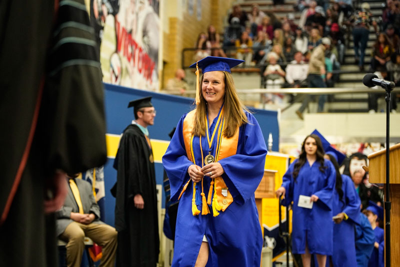 photo of a graduate walking across the stage at commencement