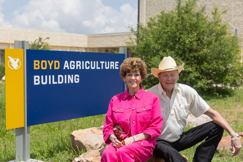 Bob and Rogene Boyd in front of the sign for the Boyd Ag Building on LCCC's campus