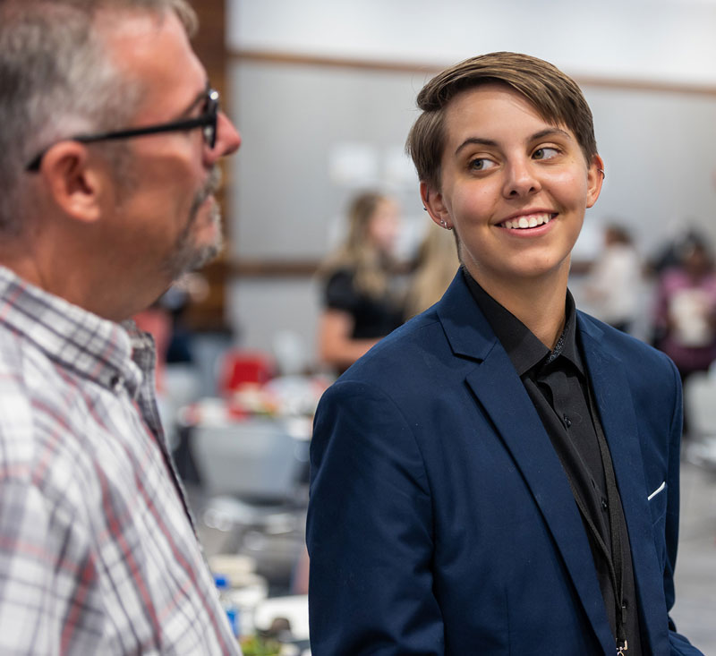 photo of a Davis First Generation Student talking to a faculty member