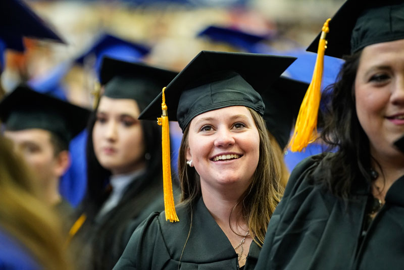 Photo of students lined up at the commencement ceremony in caps and gowns