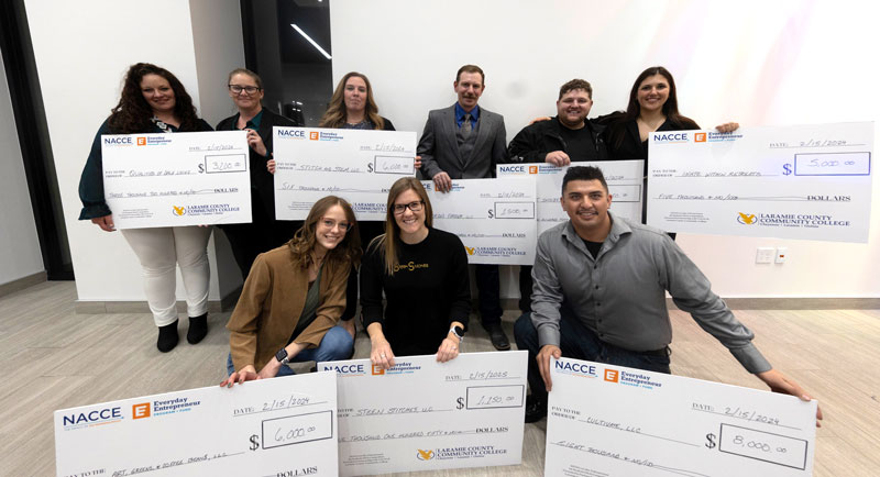 Photo of entrepreneurship contest winners with their large checks