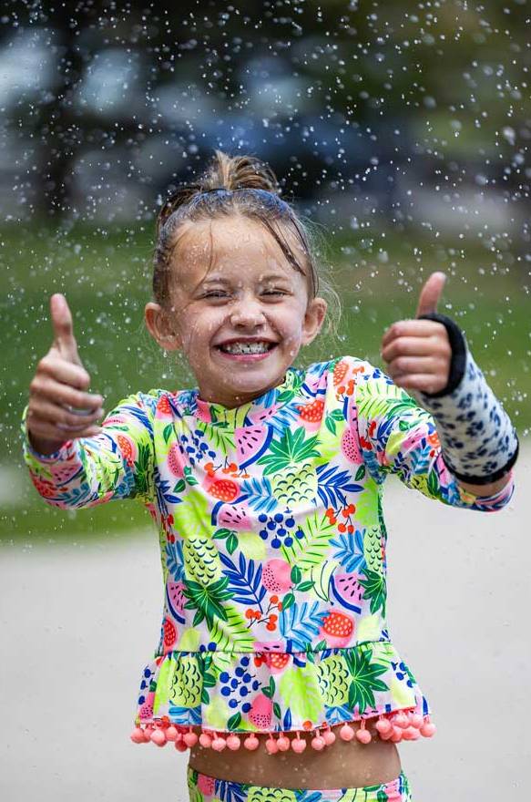 Girl enjoys outdoor time playing in the water at SEEK's June 2024 session.