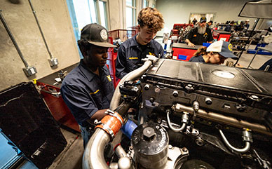 Students working on a truck engine in class