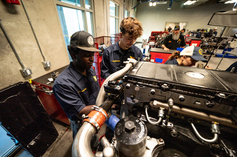 Students work on a truck engine in class