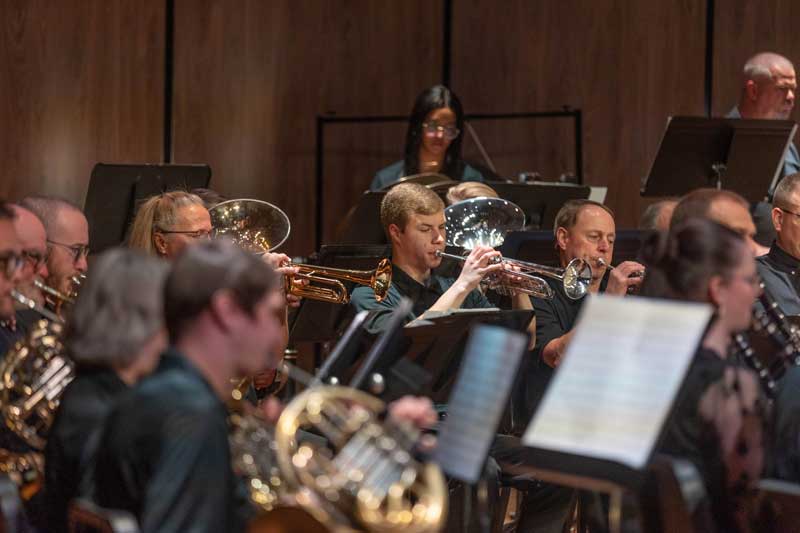 musicians playing brass instruments on stage during a concert