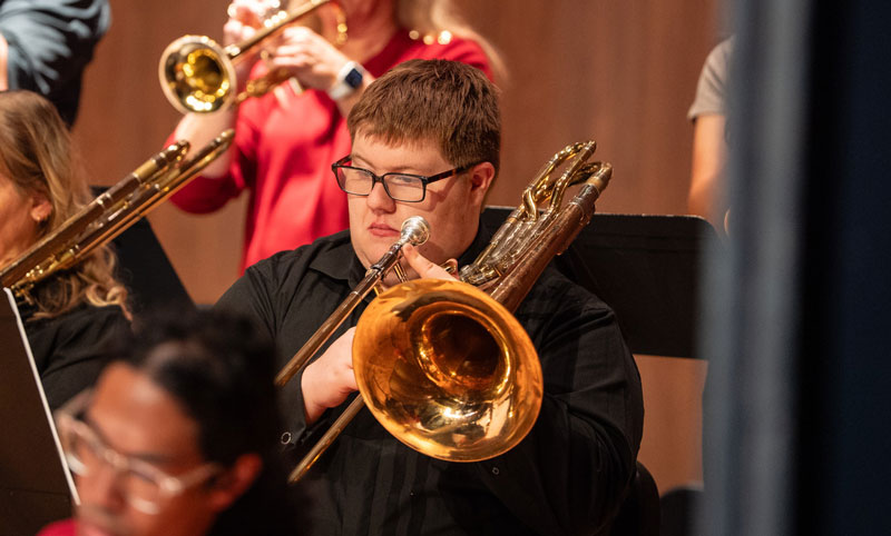 Musician playing trumpet on stage during a concert