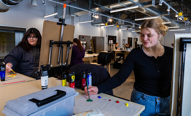 LCCC students Sarah Baynard (left) and Evelyn Slovik paint in an art class