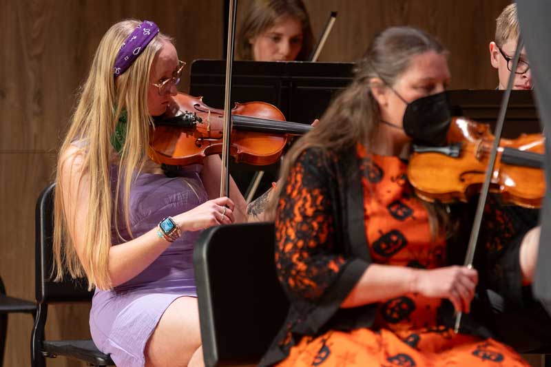 musicians on stage playing the violin and dressed in Halloween costumes for the Things that go Bump in the Night concert