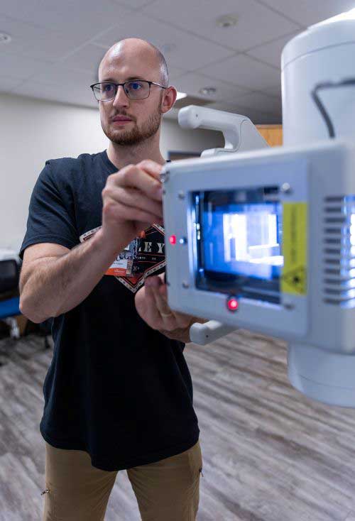 LCCC student Levi Kaiser in the radiography lab working with equipment to line up an xray