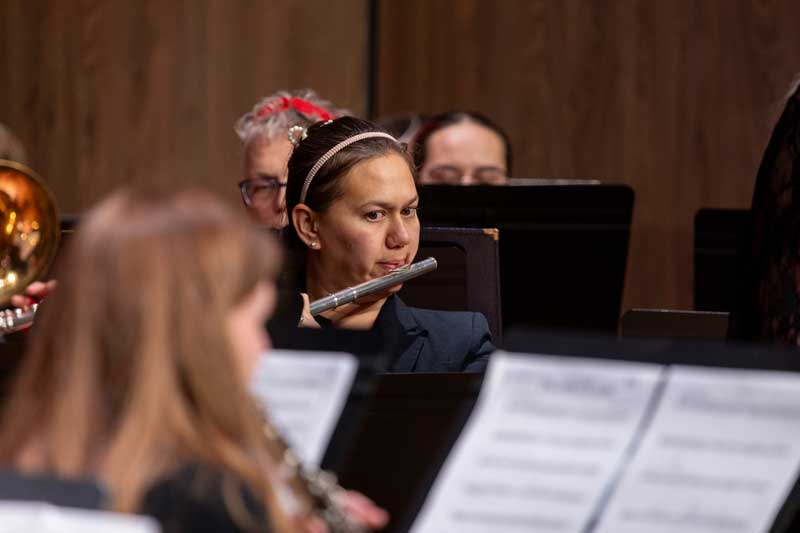 A student playing the flute on stage during a concert