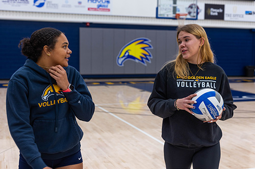 Lea, left, and Zoe, volleyball athletes at LCCC, practice fundamentals in the competition gym. 