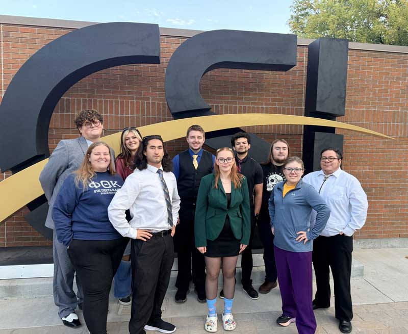 members of the LCCC speech team standing in front of a CSI sign at a speech competition in Idaho