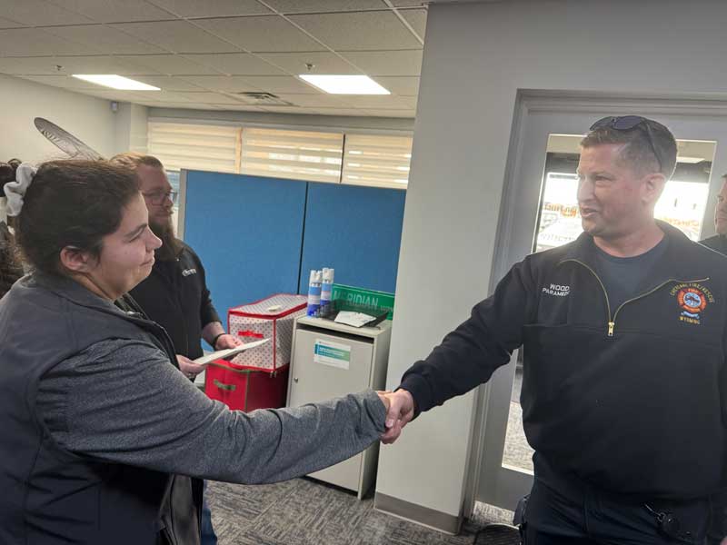 Tosha Cox is thanked by a Cheyenne Fire Rescue deputy chief.
