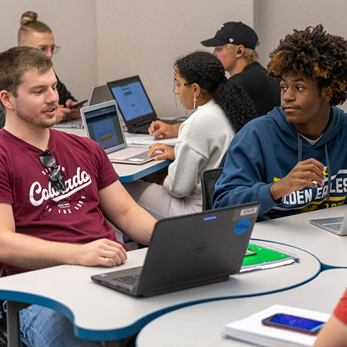 students in classroom with laptops