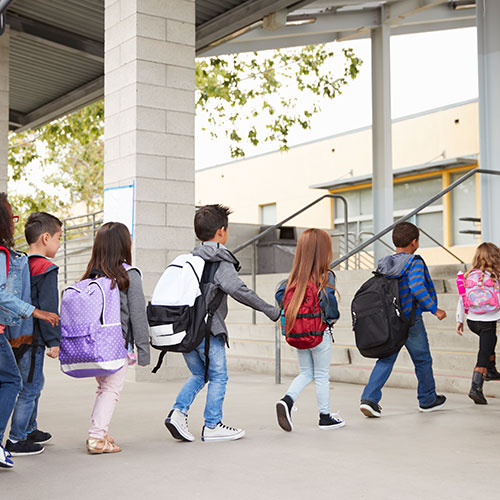 line of kids walking with backpacks