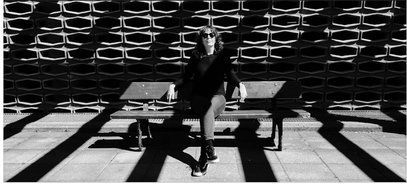 Portrait of Raquel Meyers sitting on a bench