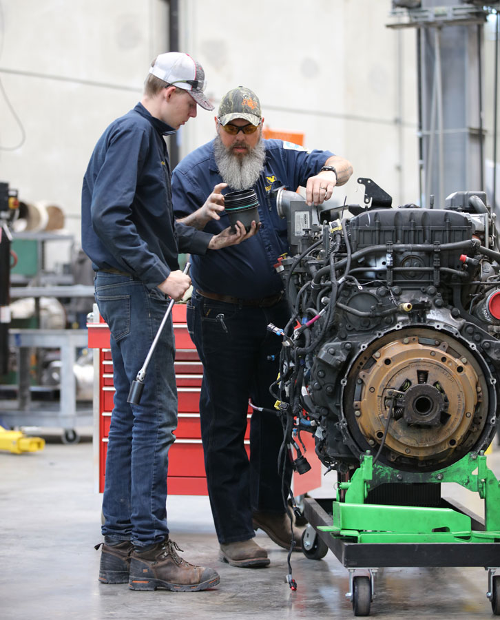 student and faculty member working on diesel engine in Flex Tech.