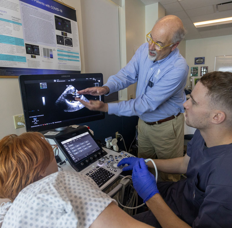 photo of an instructor talking and gesturing to images on the screen during a scan