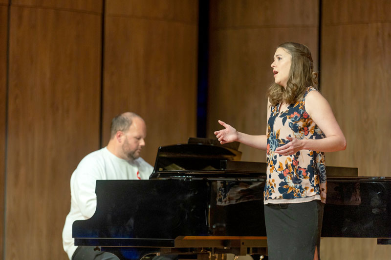 Photo of LCCC Music Faculty singing on stage with a piano in the background