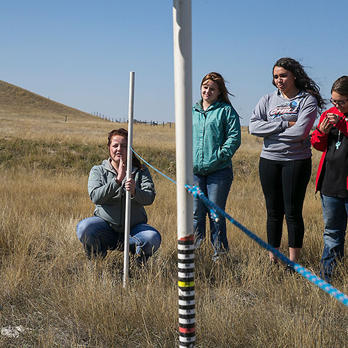 female students out in a field taking measurements