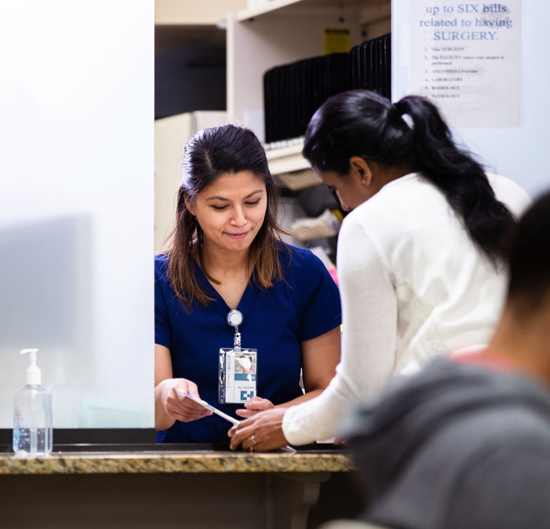 receptionist and lady talking in a healthcare facility