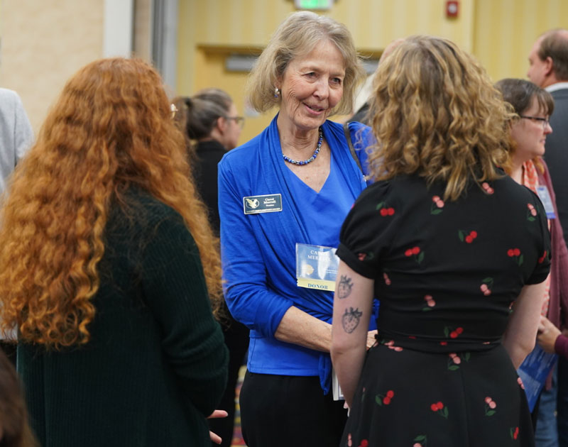 Photo of a woman talking with two students